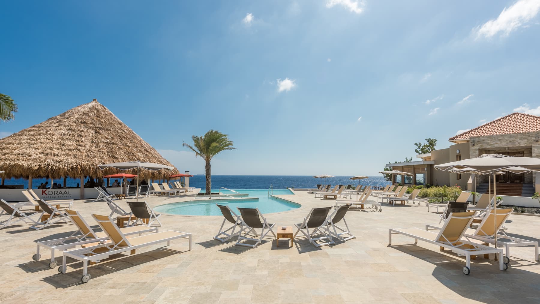 Strand met palapa's en ligbedden aan de Caribische Zee op Curaçao